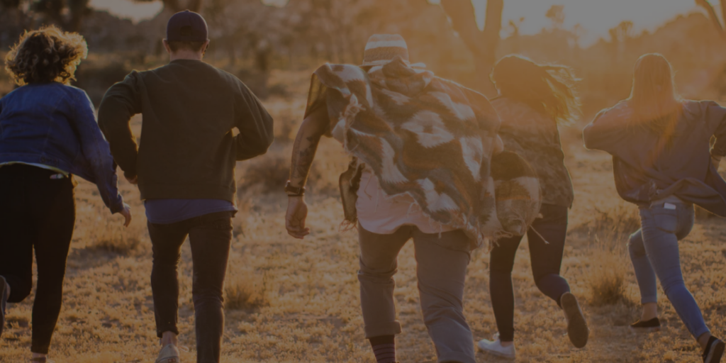 Five people running together into the sunset.